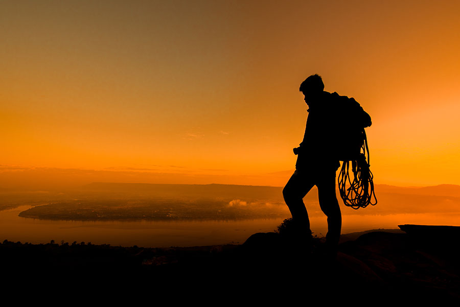 Turistas silueta en la montaña al atardecer.